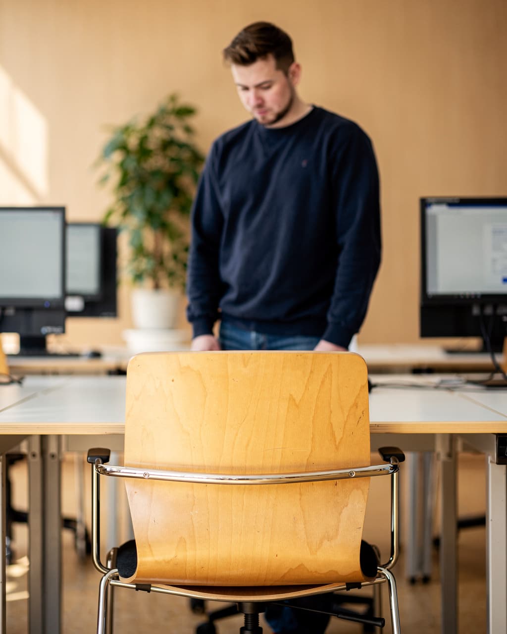 Mann an Computer-Arbeitsplätzen in einem Schulungsraum